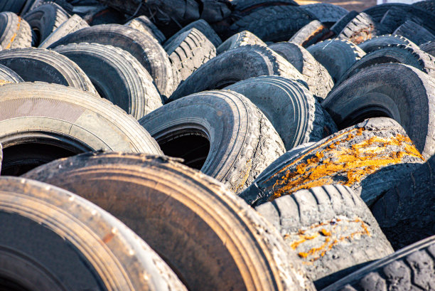一堆旧卡车轮胎在一个垃圾场的库存照片图片下载