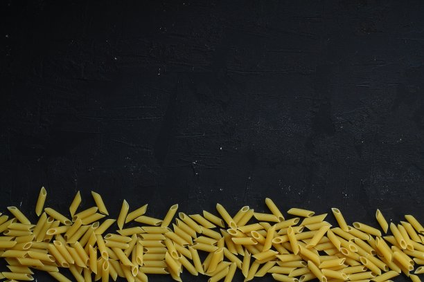 通心粉锯齿状的意大利面图案上的黑色背景，俯视图，平铺纹理图片下载
