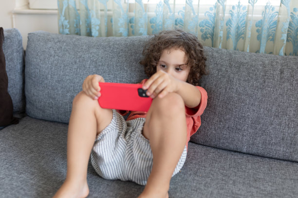 男孩在家里玩手机游戏图片下载