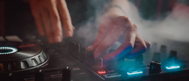 DJ手创建和调节音乐的DJ控制台混音在音乐会夜总会舞台图片下载