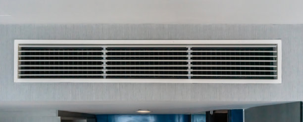 通风装置，灰色墙壁背景上的金属板条框架。有选择性的重点。图片下载