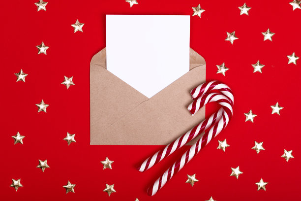 信封与一个空的喜悦和一个地方的文字上的红色背景与圣诞糖果图片下载