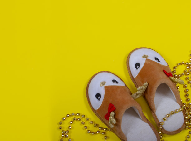 纯金串珠和家用拖鞋，圣诞鹿的形式在黄色的背景。圣诞节和新年的概念。图片下载