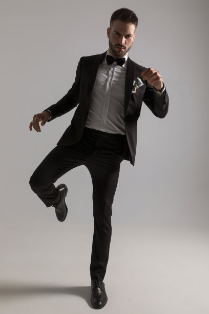 颠覆优雅的模型在黑色燕尾服举腿和踢图片下载