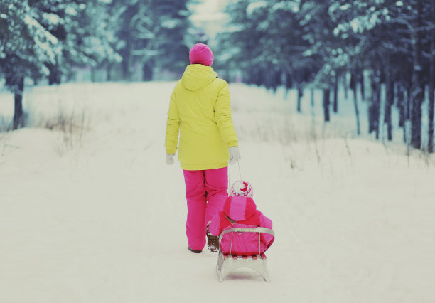 母亲和孩子在冬天的森林背景上滑雪图片下载