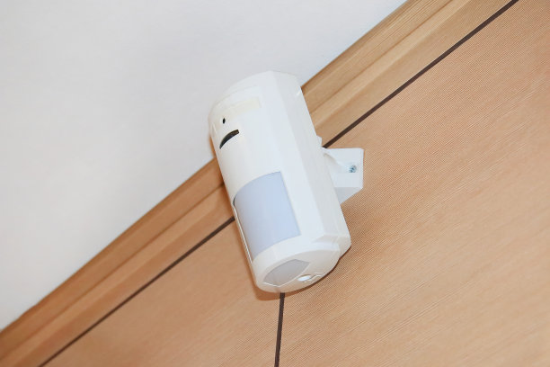 安全报警系统的运动传感器。一个白色的音量传感器挂在房间或办公室的墙上。图片下载