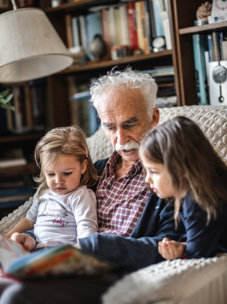 可爱的小女孩和爷爷一起读儿童读物图片下载