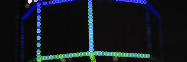 模糊的夜晚蓝色和绿色发光灯在黑色的背景。新年和圣诞节的概念。横幅图片下载