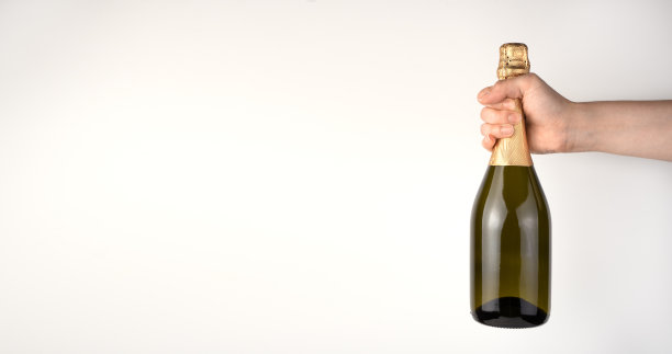 一个女人的手拿着香槟在一个明亮的背景。图片下载