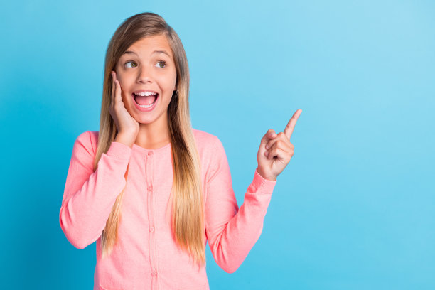 尖叫女孩的照片肖像指着空白的手指触摸脸脸颊与一只手孤立在柔和的蓝色背景图片下载