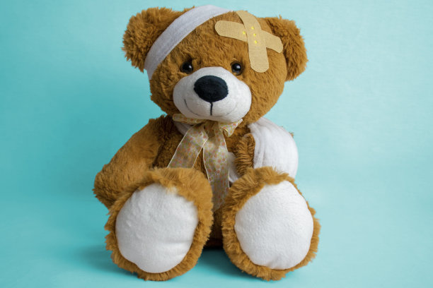 受伤的泰迪熊与绷带和石膏-儿科概念图片下载