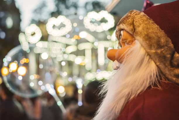 圣诞老人戴着眼镜看着圣诞彩灯图片下载