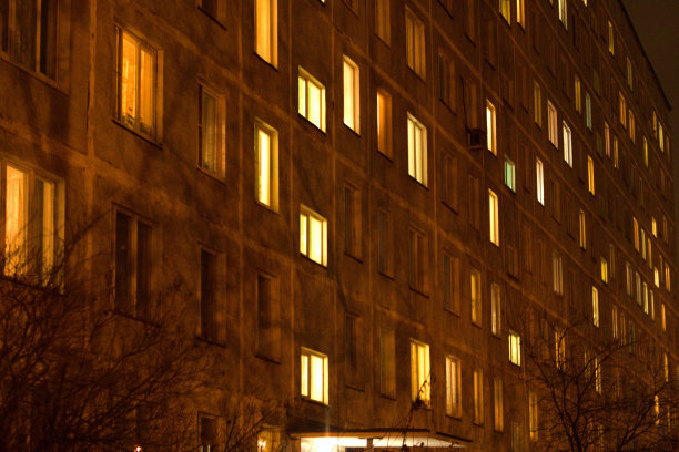 公寓大楼的立面，在晚上有发光的窗户。图片下载
