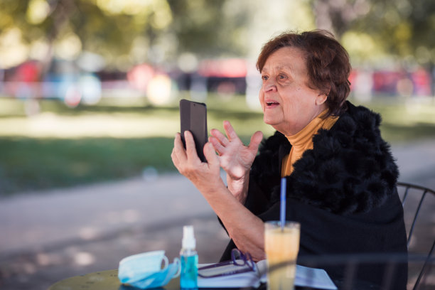 快乐的老女人通过智能手机进行视频通话图片下载