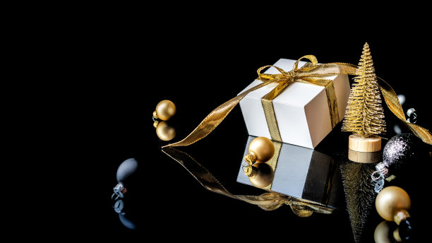 礼物的背景。白色礼盒，金色丝带，新年球和冬季树在圣诞节的组合，黑色背景的贺卡。圣诞背景与文字空间。图片下载