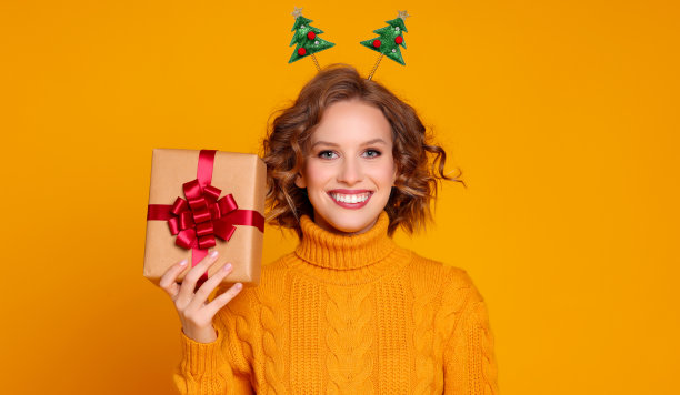 高兴的年轻女子与圣诞礼物图片下载