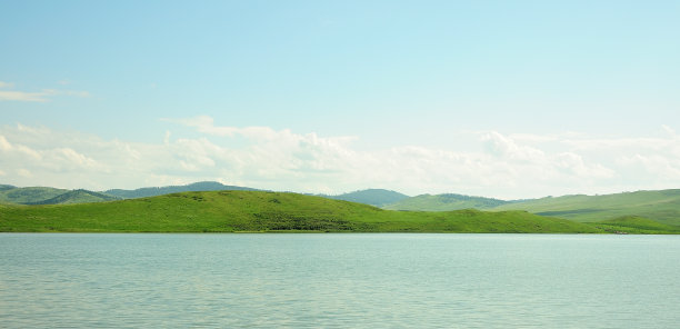 平静的湖面被夕阳所环绕的蓝山所环绕。全景拍摄俯瞰一个风景如画的山谷躺在高山脚下。图片下载