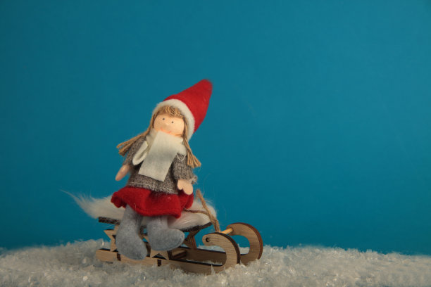 圣诞精灵在蓝色背景上孤立的雪橇上。冬天的概念。水平的形象图片下载