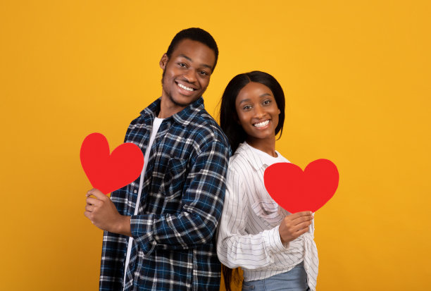 微笑的千禧一代非洲裔美国男女拿着红心看着镜头图片下载