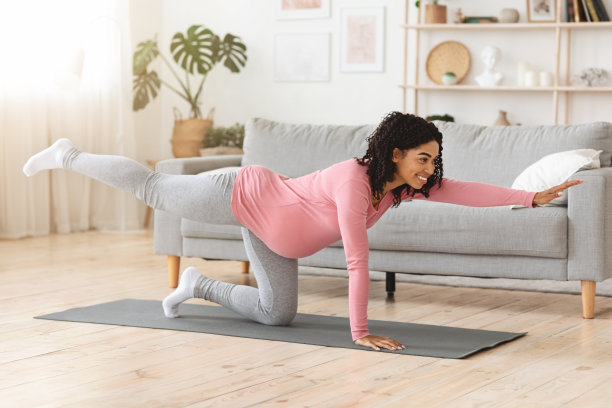 快乐的怀孕黑人妇女伸展她美丽的身体图片下载