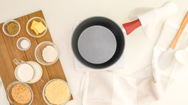 芦笋砂锅配奶油阿尔弗雷多酱淋上面包屑和帕尔马干酪一步步制作。食材靠近厨房的桌子图片下载