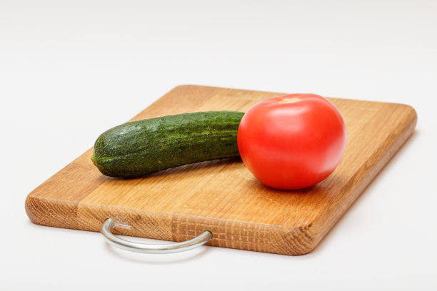 西红柿和黄瓜放在木砧板上。图片下载