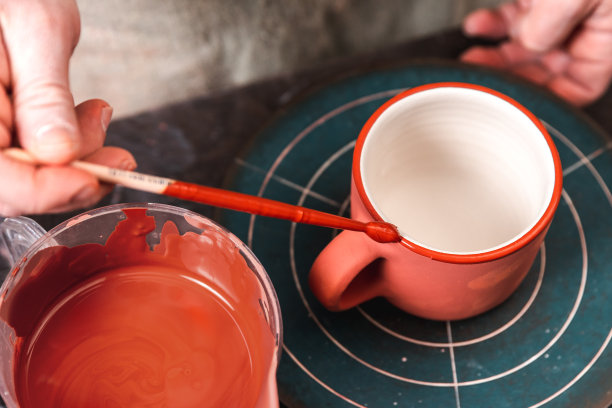 陶工或装饰师在陶艺工坊或工作室中绘制红色陶土杯，制作工艺品和手工概念图片下载