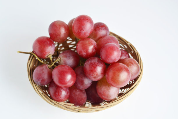 白背景下的旧篮子里的红葡萄图片下载
