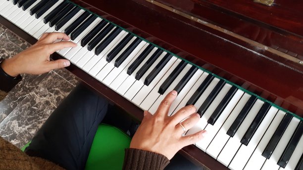 一个正在弹钢琴的年轻人的手，靠近点图片下载