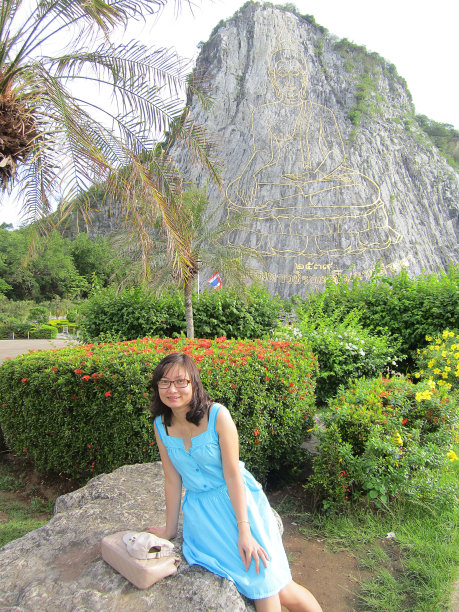 在泰国，一位妇女坐在Khau Chee Chan山前的一块大石头上图片下载