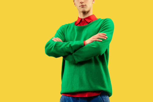 年轻男子在亮颜色的衣服孤立在黄色背景。图片下载