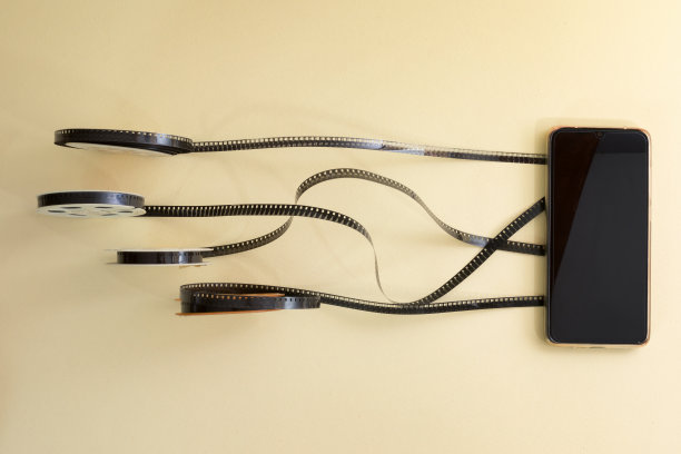 老式的胶卷卷向智能手机展开。图片下载