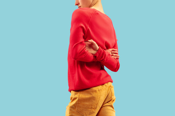 年轻男子在明亮的衣服摆姿势在蓝色的工作室背景。图片下载