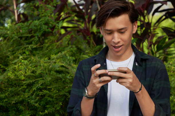 学生坐在户外公园和使用手机图片下载