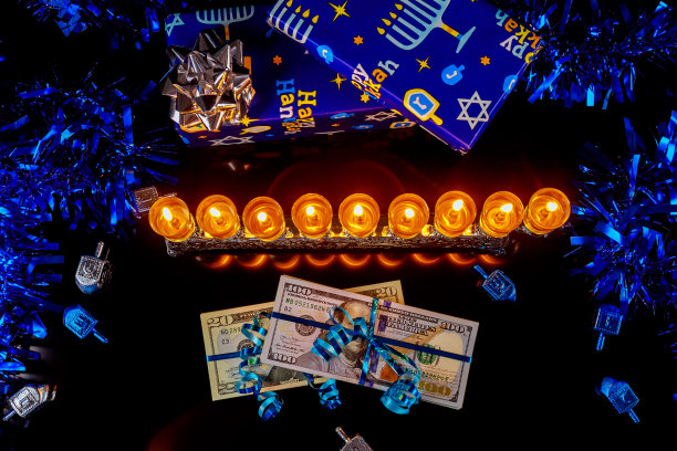 现金作为礼物与光明节的烛台在黑色的背景。图片下载