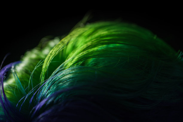 一个女孩的头发被染成明亮的颜色在黑色的背景上的特写图片下载