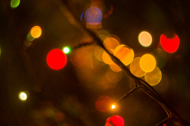 圣诞背景花环用五颜六色的彩灯装饰在圣诞树上，散焦，模糊图片下载