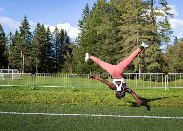 健身女孩倒立在足球场上图片下载