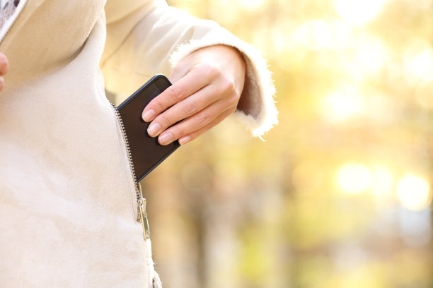 秋天，女人把手机放在夹克口袋里图片下载