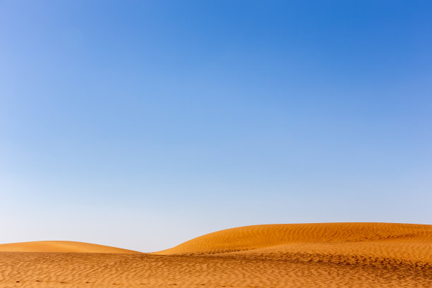 简约沙漠景观，金色沙丘，低地平线，水晶蓝天图片下载