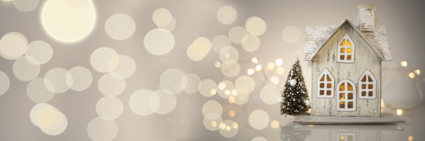 以灯光为背景的玩具房子。圣诞节和新年的装饰品。圣诞节的旗帜。素材图片