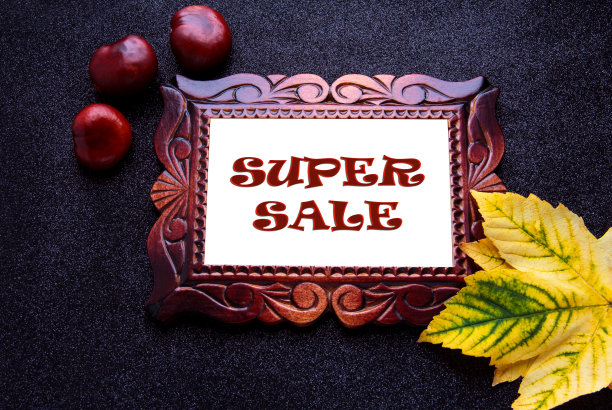 木雕框架在一个深色的背景与黄叶和铭文:超级销售。图片下载
