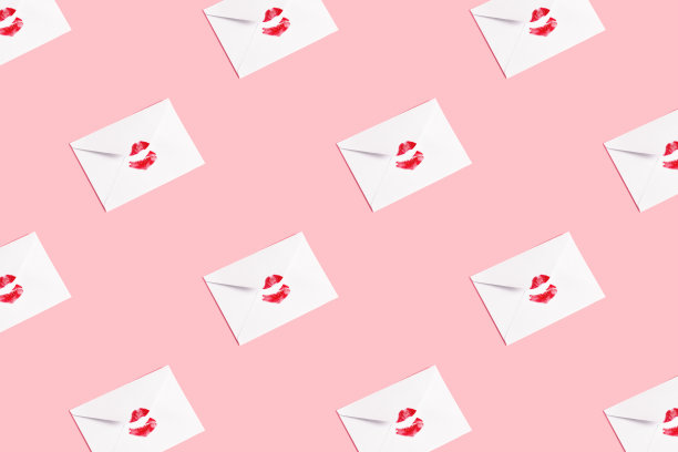 红唇之吻印在白色信封上，粉彩背景。图片下载