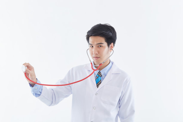 一个年轻快乐的男人医生摆着听诊器的照片。图片下载