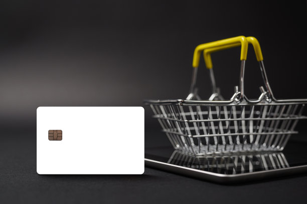 网上购物的概念。空白的白色形式的银行卡在一个黑暗的背景。图片下载