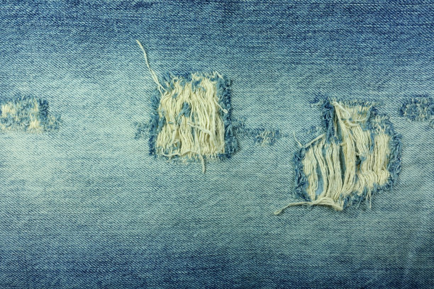 有磨损和洞的蓝色牛仔布图片下载