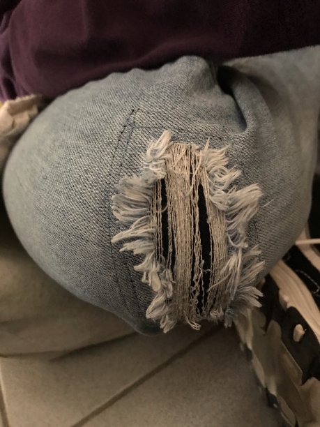 破洞的牛仔裤特写镜头。图片下载