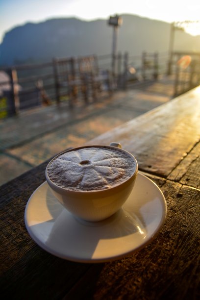 早上在木桌上放上白色陶瓷咖啡杯或可可杯图片下载