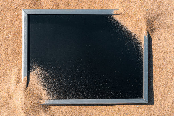 堆灰尘海滩纹理的海岸背景。堆沙漠沙孤立在黑色。假期背景与空间的文本。图片下载