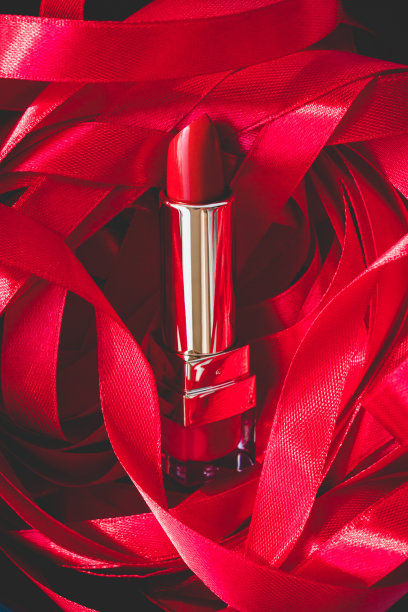 口红上的红色缎带装饰背景。专业美容化妆产品，女性喜庆礼品。前视图。图片下载